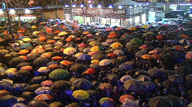 Het publiek wacht in de regen op de dj's